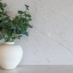 5144 Rossa Nova-Kristy Bunker project - White ceramic vase with green eucalyptus branches on a marble countertop